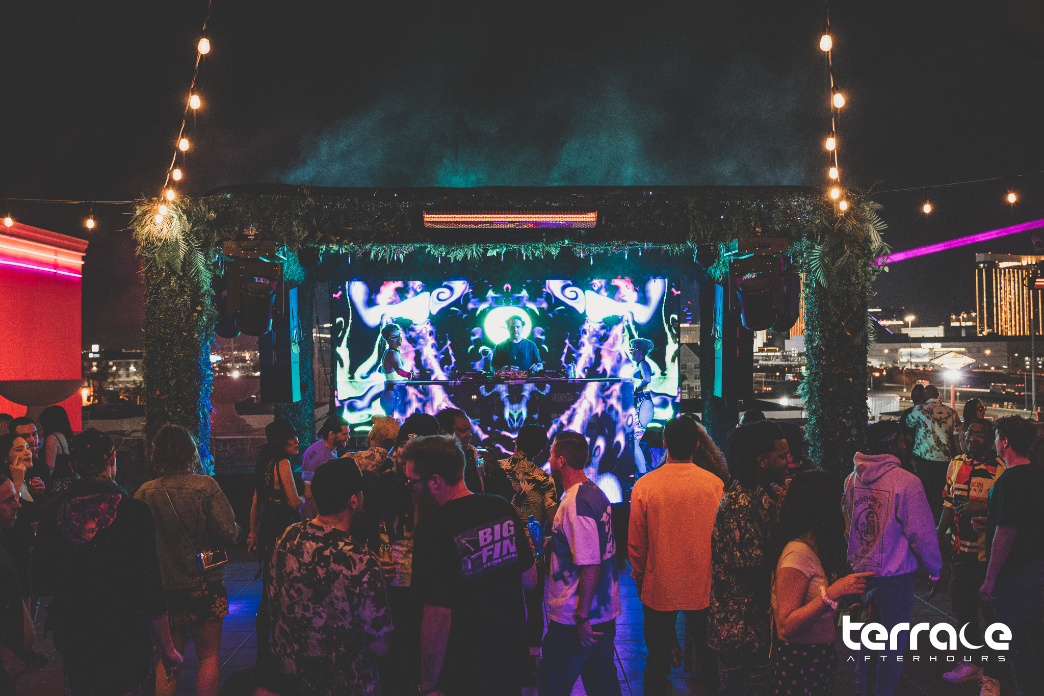 outdoor stage with LED video wall, greenery, and lights