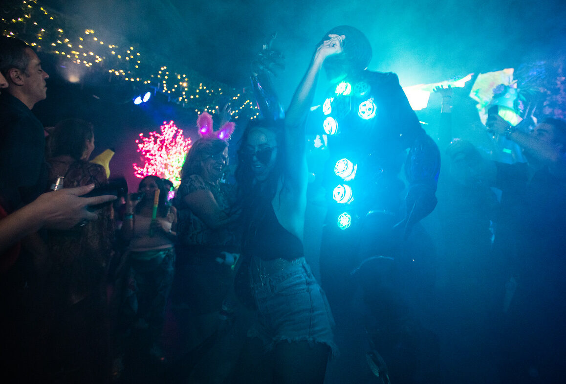 woman dancing in the crowd holding a string of lights at las vegas music event
