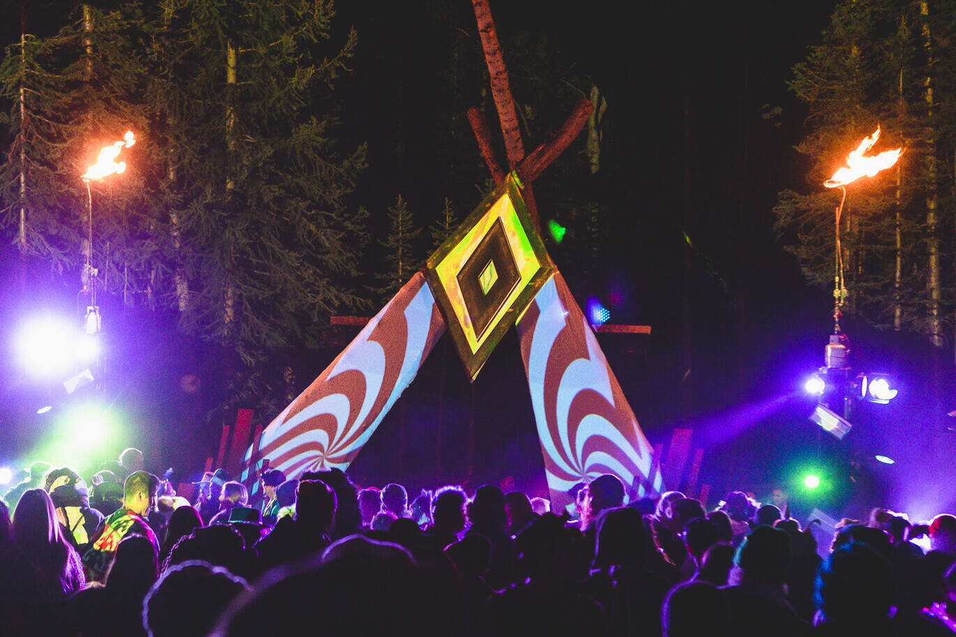 Ourdoor stage made of fabric and wood illuminated by colorful projection mapping