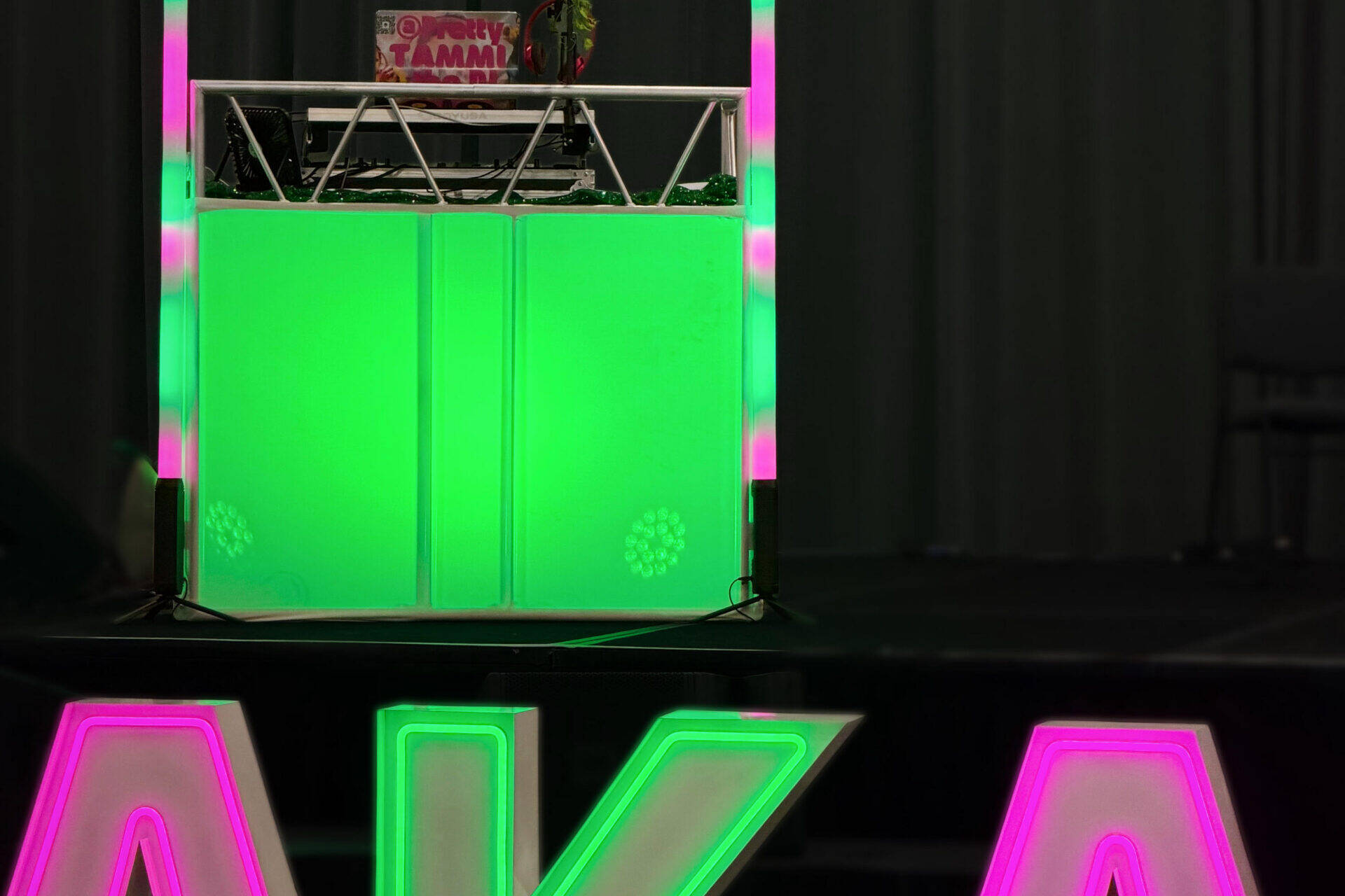 DJ booth with matching pink and green lights