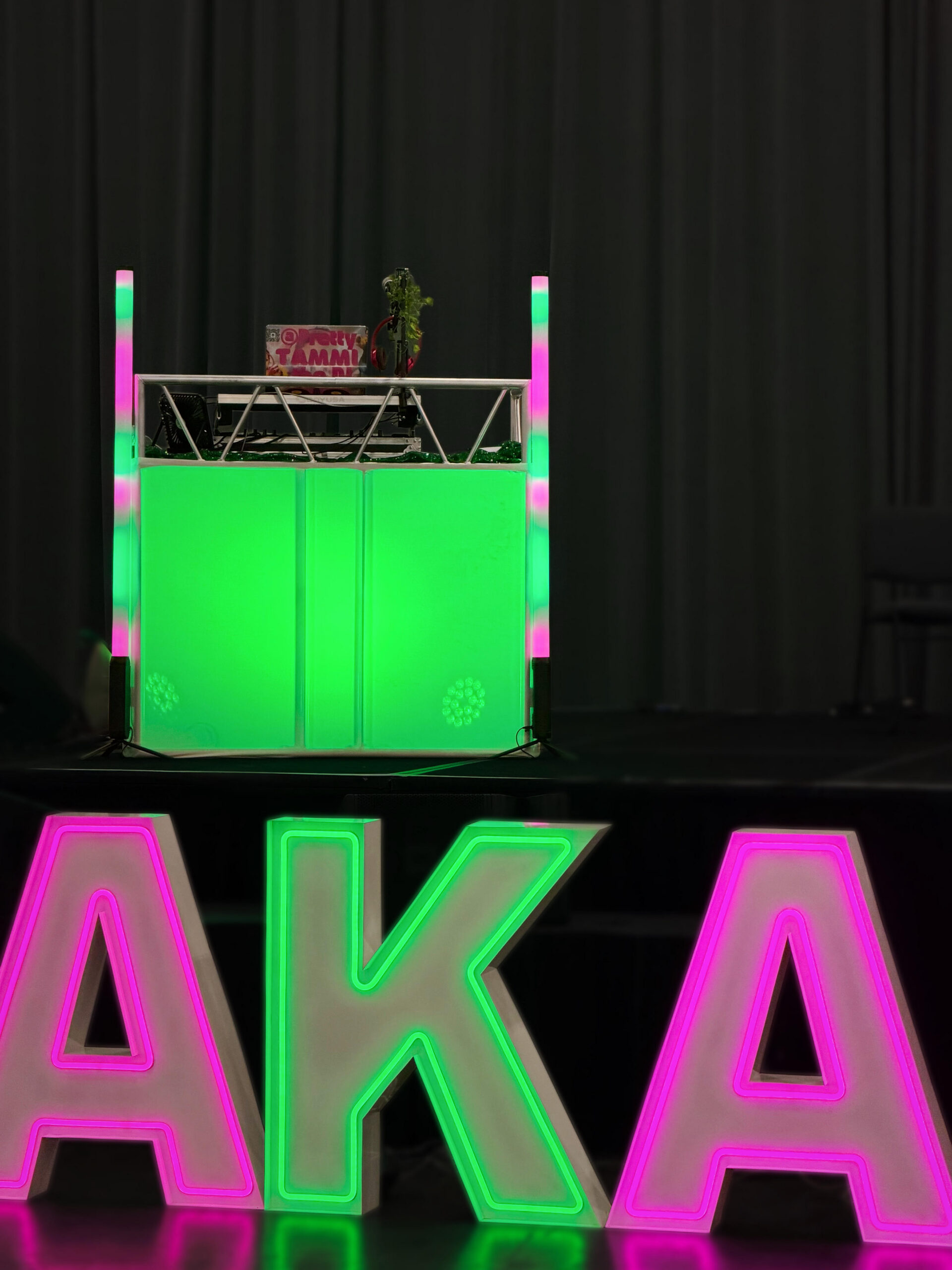 DJ booth with matching pink and green lights