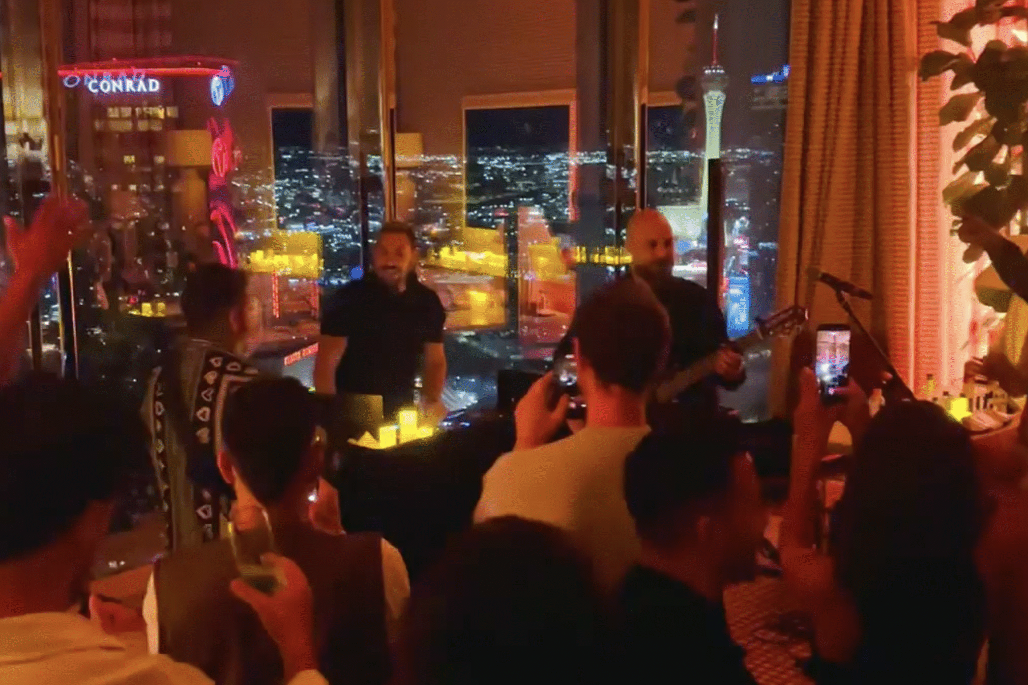 people dancing by dj booth and live band inside a vegas suite