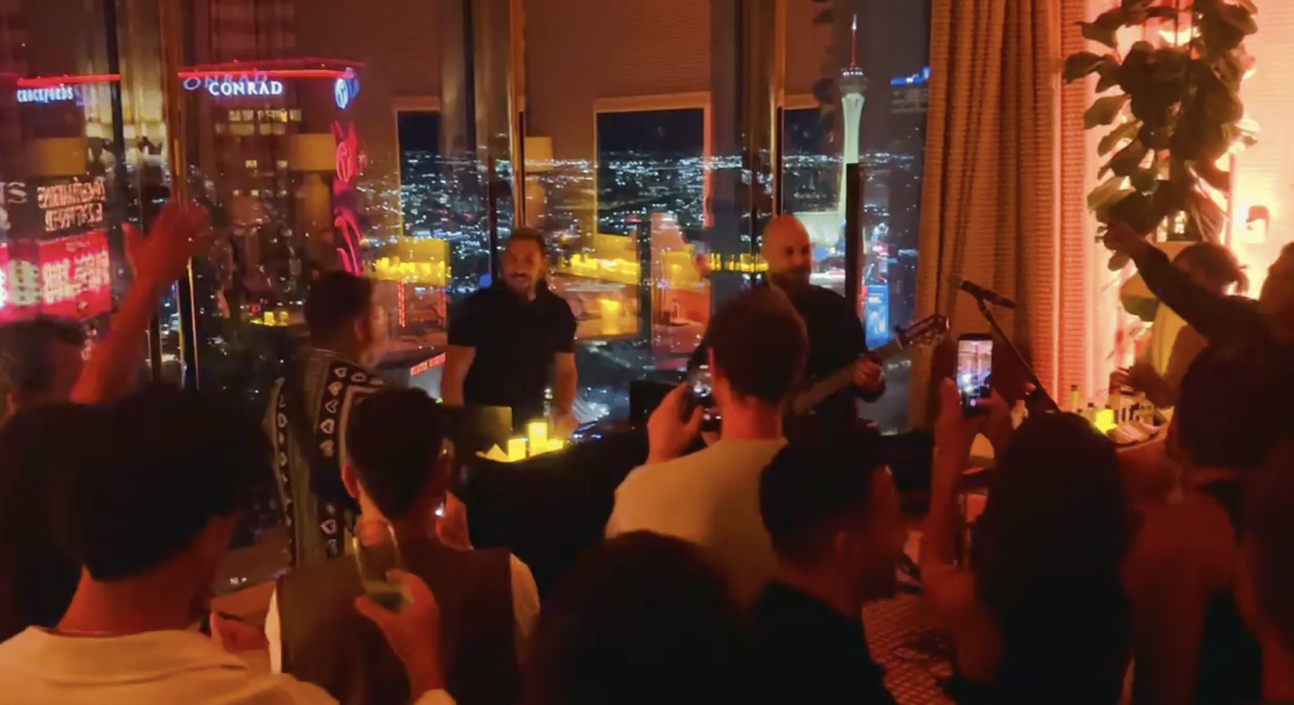 people dancing by dj booth and live band inside a vegas suite
